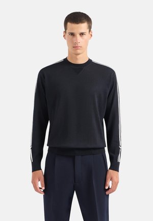 Maglione nero a maglia con maniche lunghe, strisce bianche lungo le spalle e scollatura a girocollo. Tessuto testurizzato con vestibilità comoda.