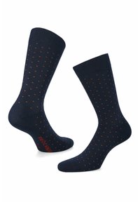 Granatowe skarpetki z małym pomarańczowym wzorem w kropki, z prążkowanym mankietem i logo na podeszwie. Bawełniana mieszanka zapewnia gładką teksturę i rozciągliwość.