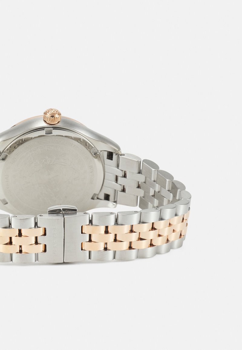 Reloj de acero inoxidable en plata y oro rosa con caja redonda, corona texturizada y pulsera de eslabones que presenta segmentos de colores alternos.