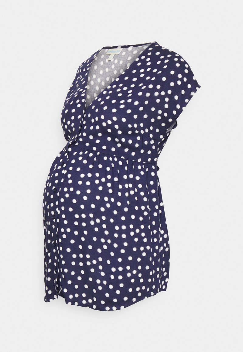 T-shirt de maternidade azul-marinho com bolinhas brancas, mangas curtas e decote em V, apresentando uma cintura franzida para maior conforto.