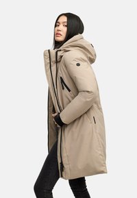 Beige isoleret parka med hætte, der har sorte lynlåse, sidelommer og ribbede manchetter. Lige snit med en glat, mat overflade.