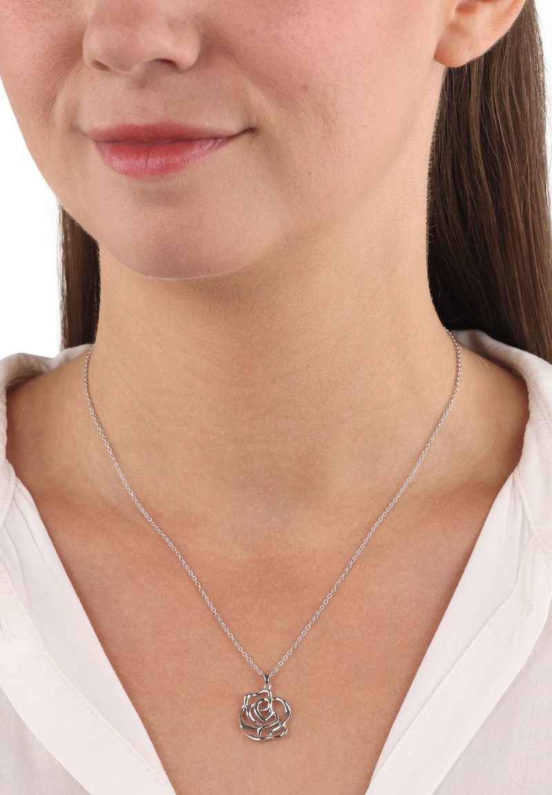 Collana d'argento con pendente a forma di rosa dal design delicato e fluido. La catena è fine e si abbina ai dettagli intricati del pendente.