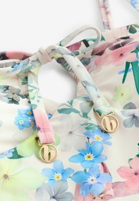 Cvetni bikini top, izdelan iz mehkega belega blaga, okrašen s pastelnimi rožicami v roza, modri in zeleni barvi. Vsebuje poudarke iz zlatih tonov.