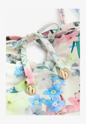 Lillelilleline bikiinitop, mis on valmistatud pehmest valgest kangast ja kaunistatud pastellsete lilledega roosa, sinise ja rohelise värviga. Sisaldab kuldse tooni metallelemente.