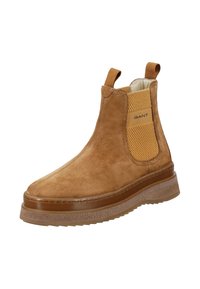 Hnědé semišové kotníkové boty s elastickými bočními panely, texturovaným zadním dílem a gumovou podrážkou s mírným platformou. Logo na boku.