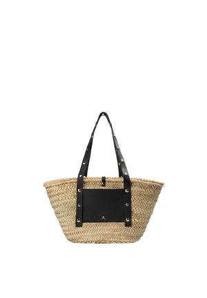 Bolsa tote de paja tejida con anchas correas de cuero negro y bolsillo frontal, adornada con tachuelas metálicas y un pequeño emblema de calavera.
