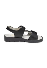 Schwarze Leder-Sandalette mit strukturiertem Obermaterial, offenem Design, Knöchelriemen und einem kleinen Schleifenakzent. Dicke Sohle für zusätzlichen Komfort.