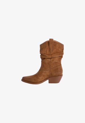 Bota de cowboy de ante marrón con un diseño caído, punta afilada y un tacón bajo. Presenta acentos de costura a lo largo de los costados.