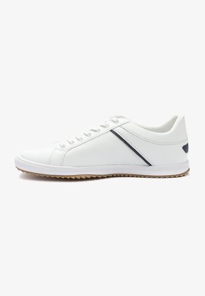 Zapatilla deportiva blanca con un upper texturizado, una raya gris que contrasta, diseño de cordones y una suela de goma con un dibujo en el neumático.