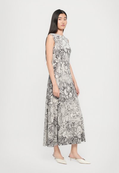 Rochie maxi cu model floral alb-negru, cu un bust ajustat și design fără mâneci, asortată cu mule albe. Textură de material neted.