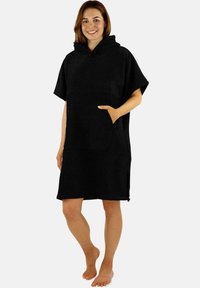 Schwarzer kapuzen Poncho aus weichem Stoff, mit kurzen Ärmeln, einer Kängurutasche und seitlichen Schlitzen für mehr Bewegungsfreiheit.