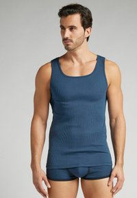 Marinblå ribbad linne och matchande figurnära boxertrosor, med en klassisk rundad halsringning och kontrasterande elastisk kant på trosorna.