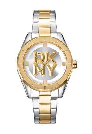 Montre en métal argenté et doré avec un cadran rond, présentant un cadran argenté et un bold logo DKNY. Le boîtier a des accents dorés et une texture brossée.