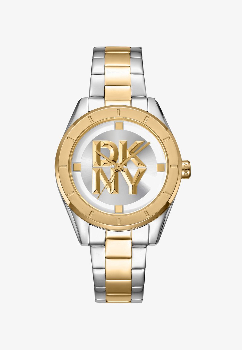 Montre en métal argenté et doré avec un cadran rond, présentant un cadran argenté et un bold logo DKNY. Le boîtier a des accents dorés et une texture brossée.