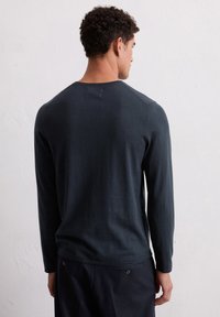 Langärmliges, dunkelblaues Hemd aus weichem Material. Hat einen Rundhalsausschnitt, Raglanärmel und ein sauberes, minimalistisches Design.