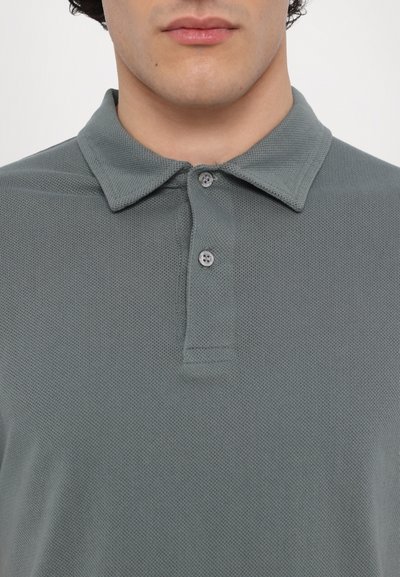 Gray polo shirt made of textured fabric, featuring a pointed collar, three-button placket, and a breathable design.