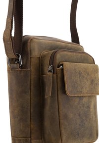 Brun læder messenger-taske med en glat tekstur, der har en frontlomme med lynlås og sidelåg, forstærkede syninger og en justerbar rem.