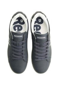 Zapatillas de deporte en azul marino oscuro con acentos en blanco, parte superior de cuero suave, cuello acolchado y suela de goma. Presentan una lengüeta con marca y una plantilla con patrón.
