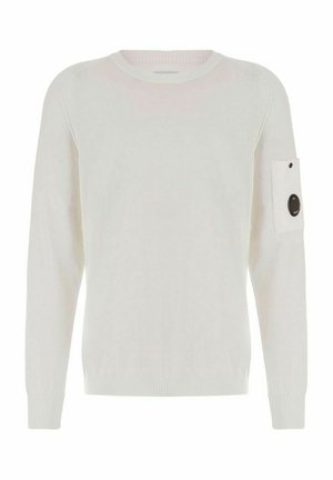 Maglione bianco a maniche lunghe con collo a girocollo, polsini e orlo a coste, con una piccola toppa rettangolare con un dettaglio circolare nero sulla parte alta della manica sinistra.
