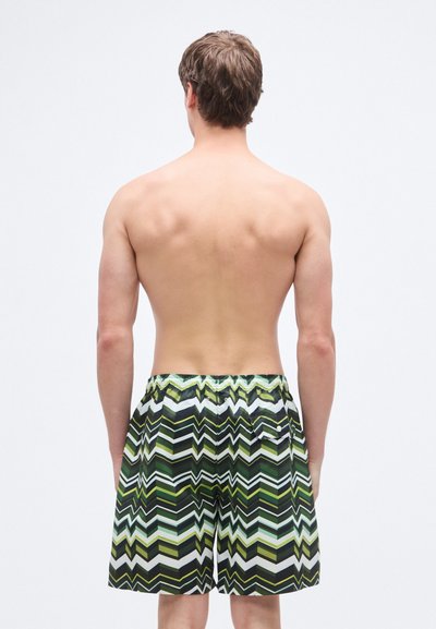 Μαγιό σορτς με ζιγκ ζαγκ μοτίβο σε πράσινο, μαύρο και λευκό χρώμα· ελαστική ζώνη μέσης· λεπτομέρεια με πίσω τσέπη.