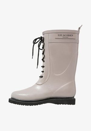 Lichtgrijze rubberen regenlaarzen met een ronde neus, zwarte vetersluiting aan de voorkant en een getextureerde bovenkant. Dikke zwarte zool met witte stiksels.