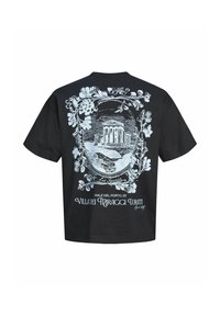 T-shirt noir avec un cadre floral décoré blanc entourant un croquis d’un bâtiment classique et d’un paysage, étiqueté « La Spezia » avec un texte en dessous.