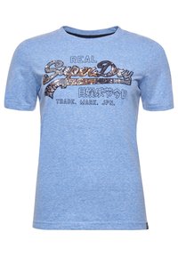 Camiseta de manga corta azul hecha de una tela suave. Presenta el logo 'SuperDry' en acentos brillantes y texto negro. Cuello redondo clásico.