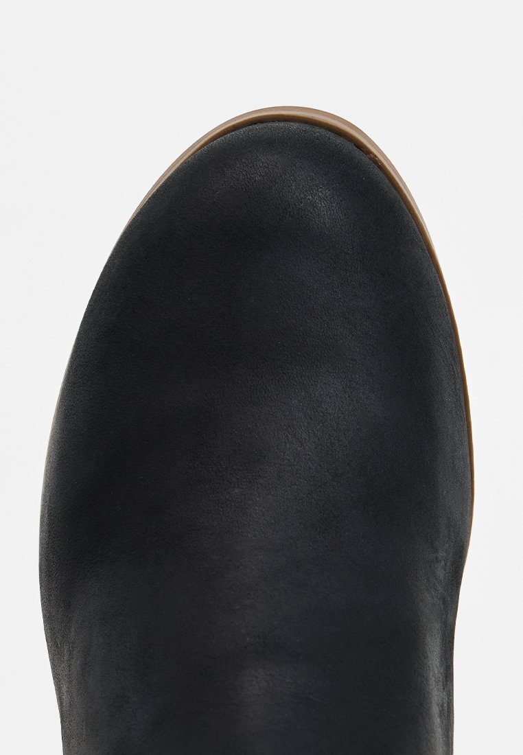 Zwarte leren laars met een gladde textuur, ronde neus en een lichtbruine zool, met een minimalistisch ontwerp en geen zichtbare hardware.