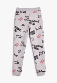 Graue Sweatpants aus einer Baumwollmischung, mit gemischten Textgrafiken in Schwarz und Rot, elastischem Bund und schmalen Bündchen.