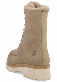 Beige semišové kotníkové boty s límcem z umělé kožešiny, šněrováním v přední části a texturovanou gumovou podrážkou. Na boku mají logo a prošívané detaily.