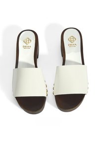 Witte slidesandalen met een brede band, houten hak en gouden accenten aan de zijkant. Glad oppervlak en open teenontwerp.