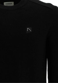 Maglione nero a maglia con scollo rotondo, accenti sulle spalle e una piccola patch con logo sul petto. Texture liscia con design aderente.
