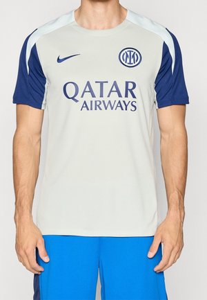 Mann trägt ein weißes und blaues Nike-Sporttrikot mit Inter-Mailand-Logo und Qatar Airways-Sponsor, kombiniert mit blauen Shorts.