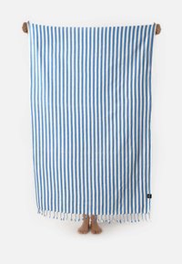 Cotton beach towel featuring alternating blue and white vertical stripes, with a fringed edge at the bottom. Dimensions are large.