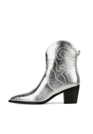 Bota vaquera plateada con punta afilada, acabado metálico texturizado, costuras decorativas en espiral y un tacón corto cuadrado.