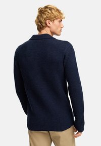Maglione in maglia testurizzata blu navy con colletto a scialle e maniche lunghe, dotato di un orlo dritto e una vestibilità leggermente rilassata.
