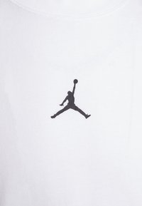 Vit bomulls t-shirt med en svart "Jumpman"-logotyp tryckt i mitten. Mjuk textur med en klassisk rundhalsdesign.
