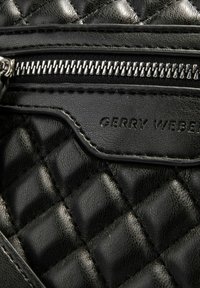 Borsa nera in pelle trapuntata con zip argentata, logo "GERRY WEBER" impresso e superficie testurizzata distintiva con motivi a diamante.