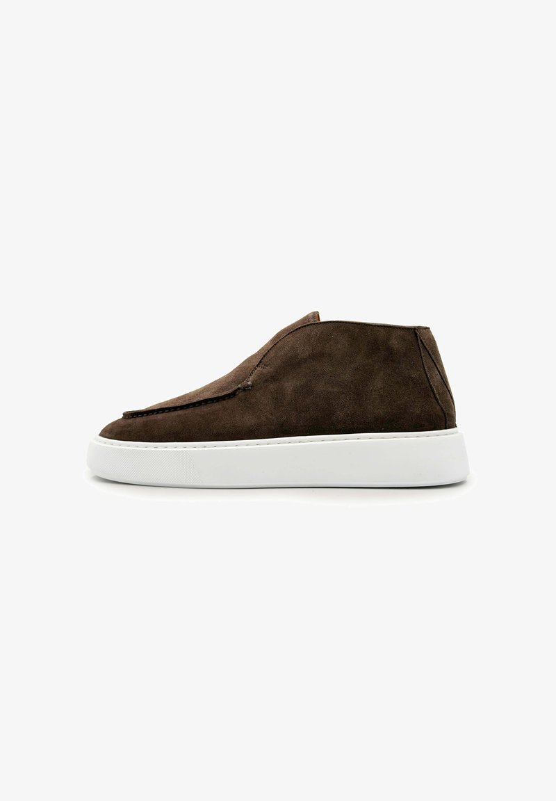 Bruine suède instapsneaker met een high-top ontwerp en een dikke witte rubberen zool, zijwaarts gezien op een witte achtergrond.