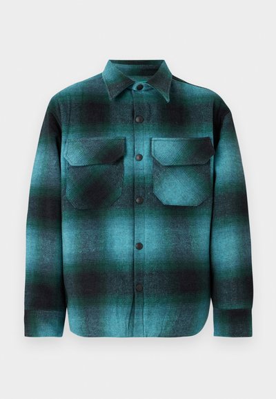 Camicia a quadri in turchese e nero, con due tasche sul petto, chiusura a bottoni, colletto e maniche lunghe con una texture morbida.