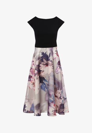 Zwarte, getailleerde lijfje met korte mouwen gaat over in een vloeiende rok met een bloemenpatroon in pastelkleuren met plooien.