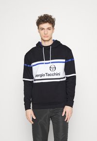 Černá mikina s bílo-modrými horizontálními pruhy. Obsahuje logo na přední straně a kapuci se stahovacími šňůrkami. Vyrobena z měkké látky, má ležérní design.