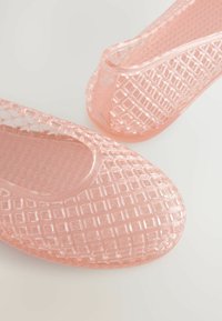 Transparente pinkfarbene Kunststoff-Schlupfschuhe mit einem strukturierten Diamantmuster, abgerundetem Zehenbereich und niedrigem Schaft für ein einfaches Anziehen.