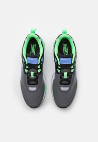 Gray athletic shoes with green and blue accents, textured material, lace-up design, and padded collars. Prominent Puma logo on the tongue.