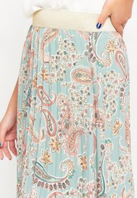 Lightweight, pleated skirt in teal with paisley pattern, featuring pink and floral accents. Elastic waistband for comfort.