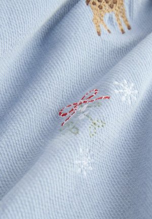 Lys blå tekstureret stof med broderede designs, herunder en giraf, rød sløjfe og hvide snefnug, med et blødt, vævet udseende.