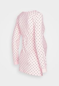 Vestido de manga longa cor-de-rosa claro com bolinhas vermelho-escuras, cintura franzida, decote arredondado e punhos ajustados. Textura de tecido suave.
