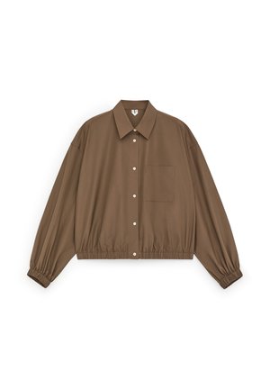 Brązowa krótka koszula na guziki z długimi rękawami, elastycznymi mankietami, szpiczastym kołnierzem i kieszonką na piersi na białym tle.