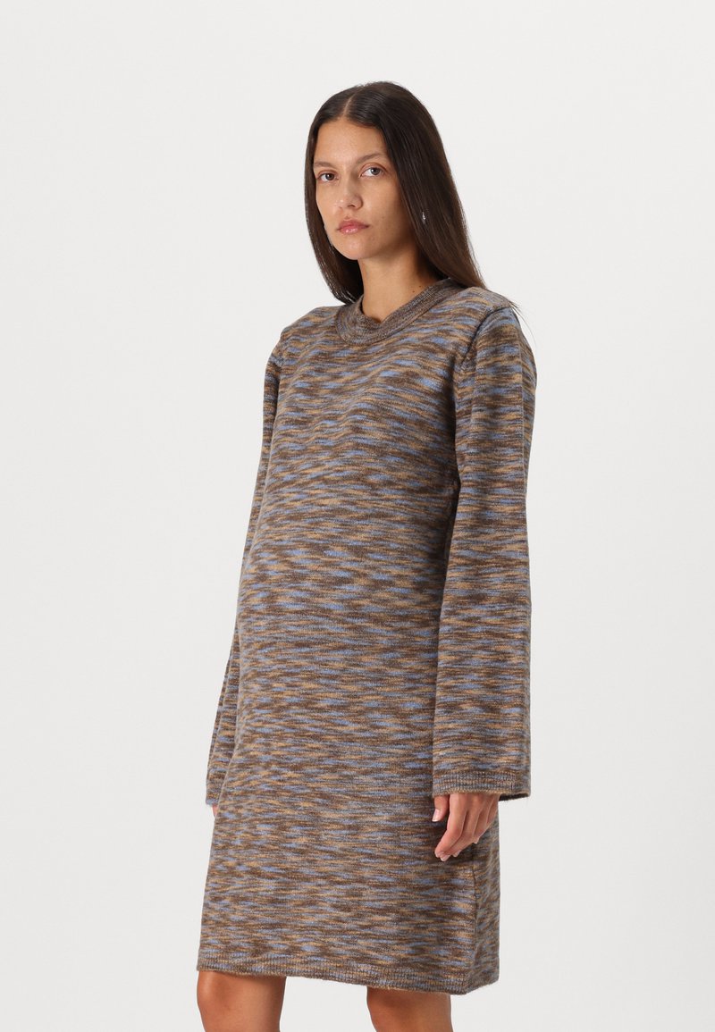Robe de longueur genou à col rond, marron avec des motifs texturés bleus et oranges. Manches longues, tissu en tricot doux, fentes sur les côtés.