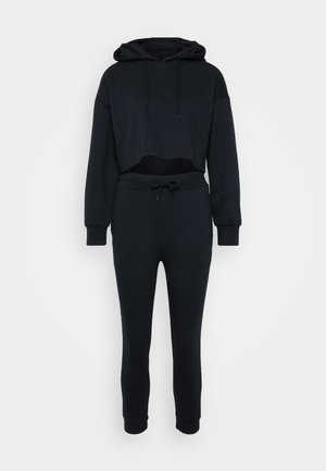 Hoodie preto cropped com cordão e calças de treino ajustadas combinando. Tecido suave, punhos e cintura canelados com cordão ajustável.